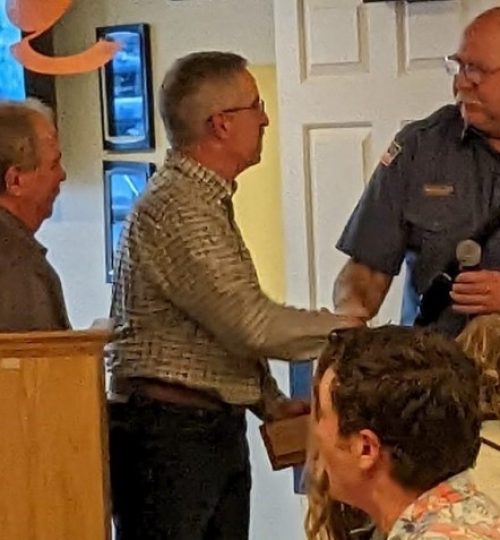 Volunteer of the Year Keith Fuggles accepting his award from Captain Minor.